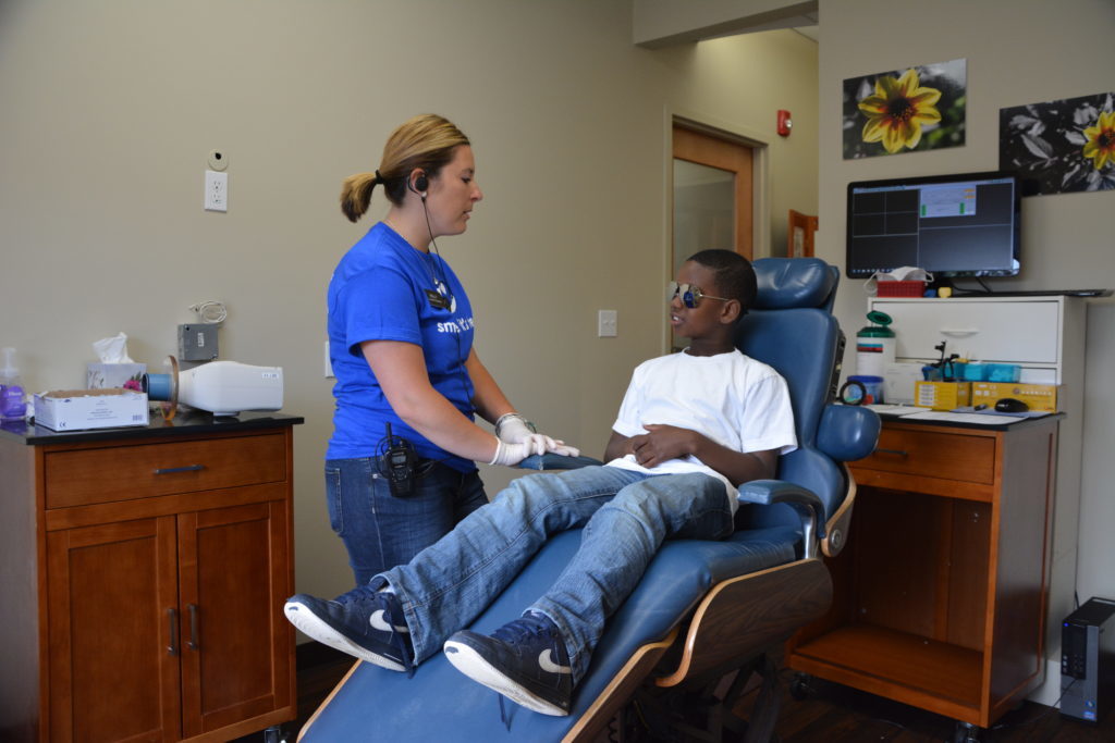 Staff work with a kids dentistry patient coming in for a routine teeth cleaning at Cigno Family Dental in Greenfield, WI.